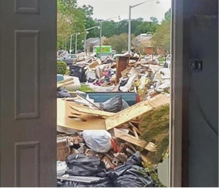 Looking through a door into the street piled with debris and a green truck in the background